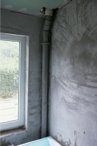 Einwandige Leitung platzsparend hinter der Badewanne kraftschlüssig per Schelle in einer Raumecke. Da herrscht "Fehlanzeige" bei Hinterlüftung, Brandschutz, Längendehnung und einfacher Demontagemöglichkeit. 