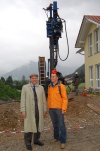 Weltmeister und Olympiasieger Michael Greis (rechts) zusammen mit Dr. Ulrich Stiebel, einem der beiden Inhaber von STIEBEL ELTRON. Im Hintergrund wird vom Geowell-Team gerade die Sondenbohrung vorgenommen, über die später die Wärmepumpe im Hause Greis mit kostenloser Umweltenergie aus dem Erdreich versorgt wird.<br />