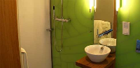 Die minimale Nasszelle lässt sich durch flexible Wände im Norden in ihrer Grundfläche verdoppeln. Sanitärobjekte der Firma Duravit und das klaren Design der Armaturen in Küche und Bad der Firma Dornbracht bieten einen angenehmen Raumeindruck.