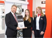 DGNB-Mitarbeiterin Claudia Wartmann (Mitte) überreichte Vertriebsleiter Ewald Koopmann und Kerstin Wösten (Vertrieb) das DGNB Navigator Label für die Wildeboer-Brandschutzklappen. Bild: Wildeboer