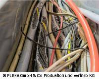Beschädigte Kabel an einer Maschine ohne entsprechenden Schutz 